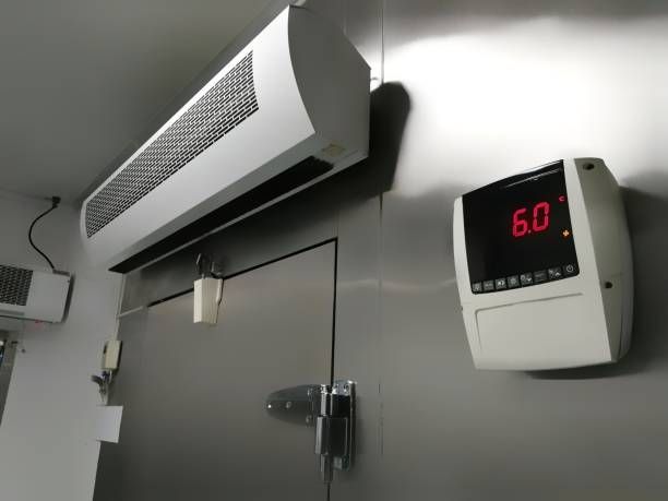 White air conditioning unit and digital display on a gray wall, showing the number 6.0 in red.