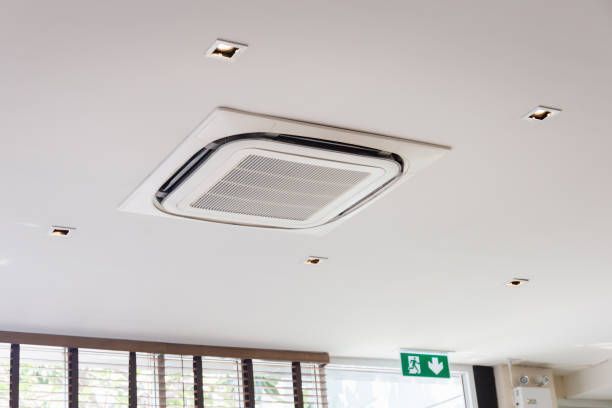 White ceiling with recessed air conditioner and small recessed lights.