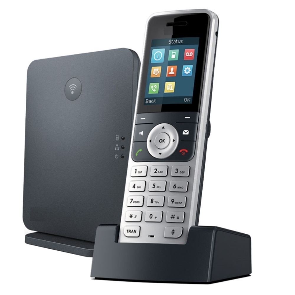 Een draadloze telefoon staat op een oplaadstation naast een zwarte doos.