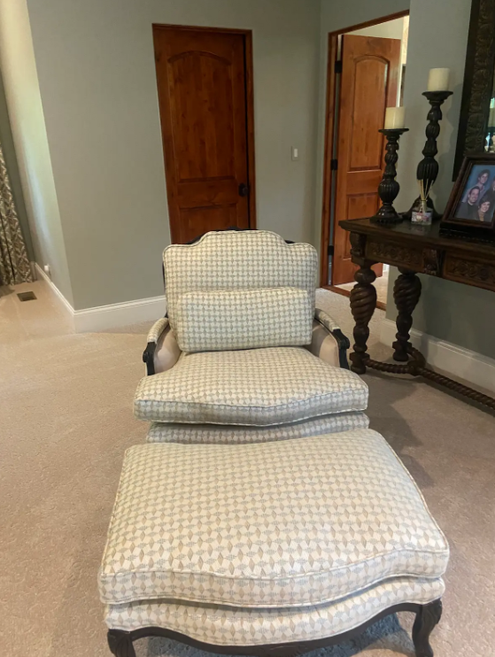 Two-piece cushioned chaise lounge with plaid fabric in a living room near wooden doors and a side table.