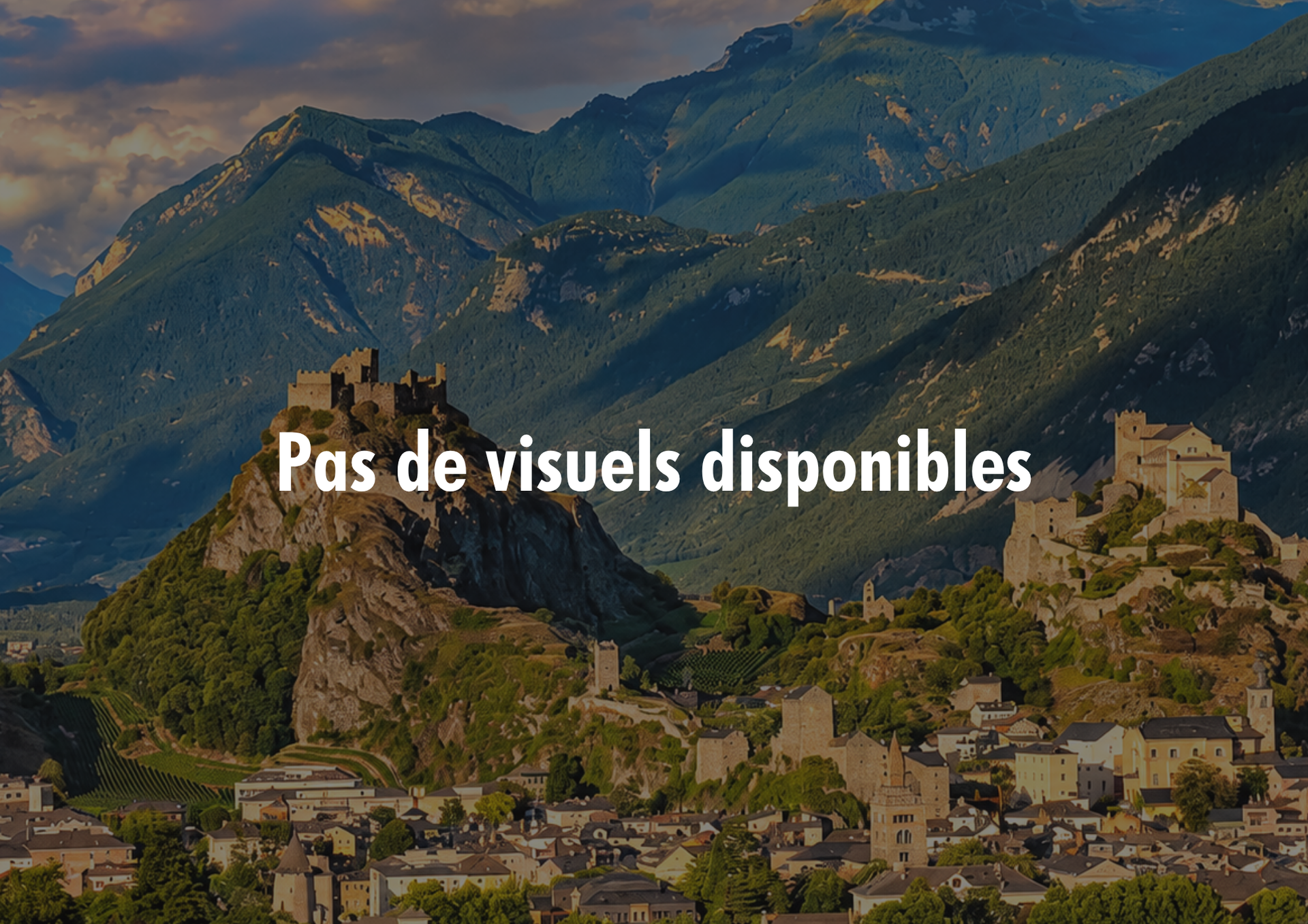 Village de montagne aux bâtiments en pierre dans une vallée verdoyante, au pied de pics escarpés, sous un ciel nuageux. Texte « Pas de visuels disponibles ».