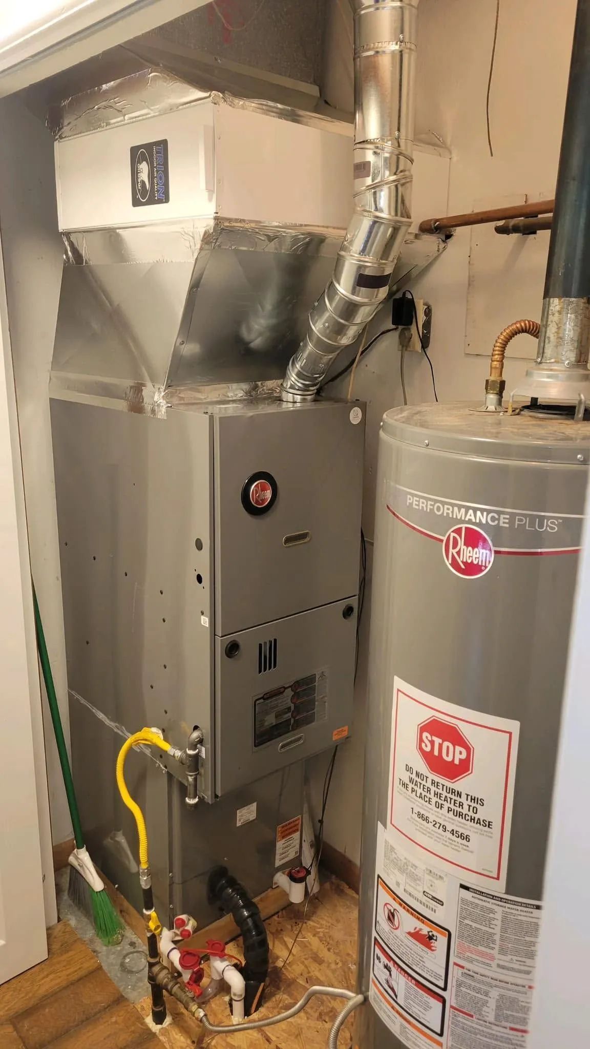 Basement utility room with furnace, water heater, and metal ductwork.