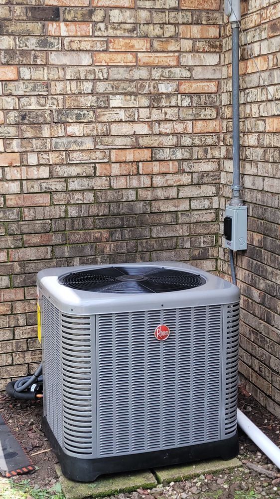 Outdoor HVAC unit beside a brick wall and corner conduit on a concrete pad