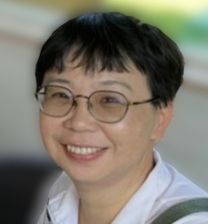 一頭黑色短髮、戴眼鏡的女子身穿白襯衫,面帶微笑。