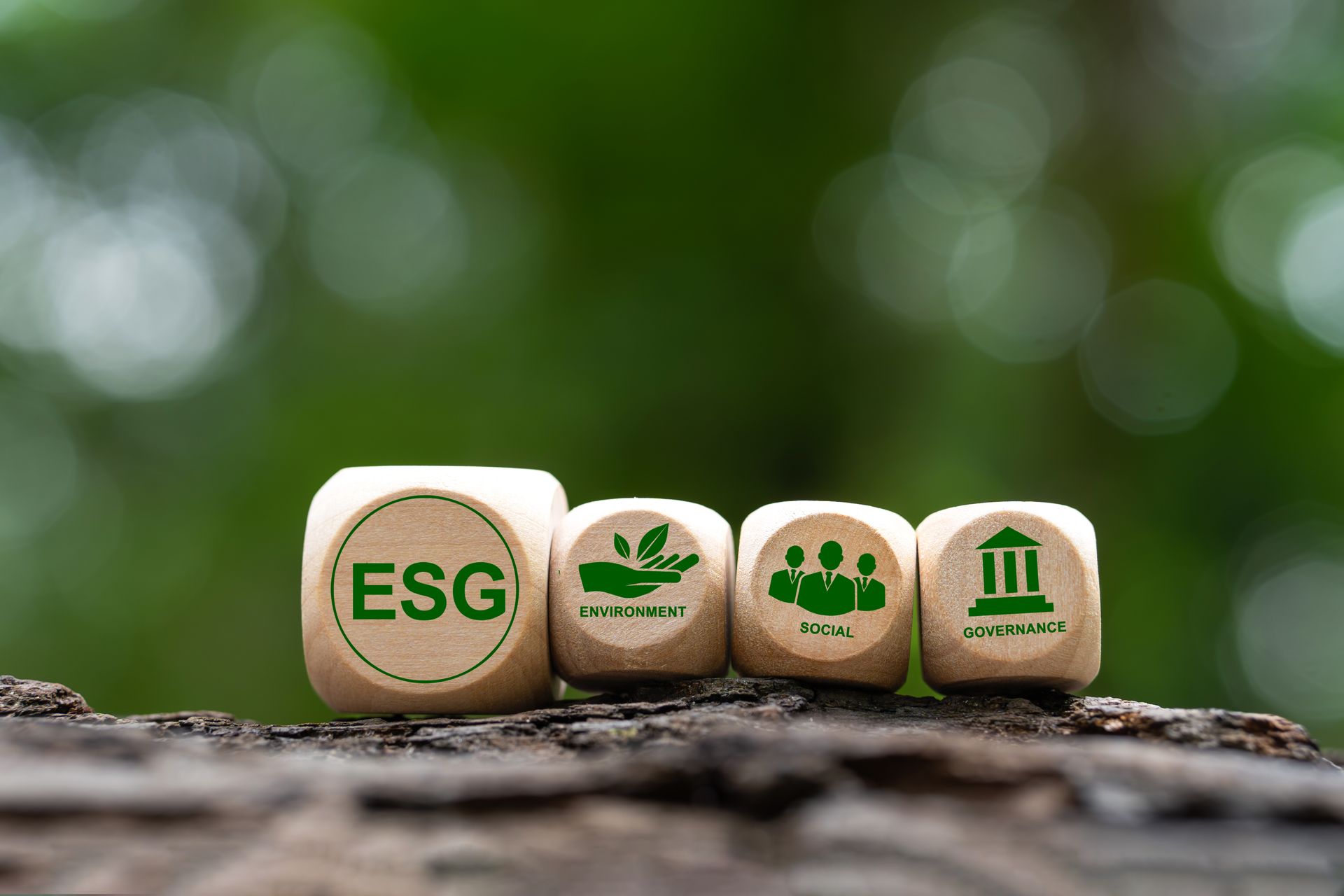 帶有綠色ESG符號的木塊:環境、社會、治理。綠色背景。