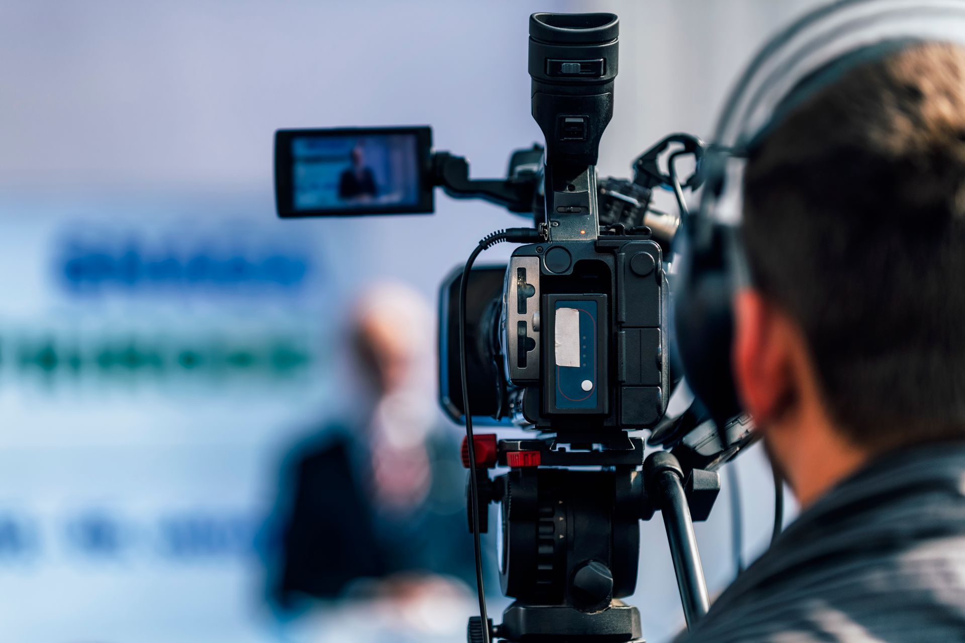 有人在用攝影機拍攝;背景中有模糊的身影。