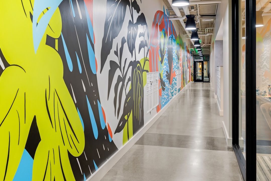 Colorful mural-lined hallway with polished floors and overhead lights