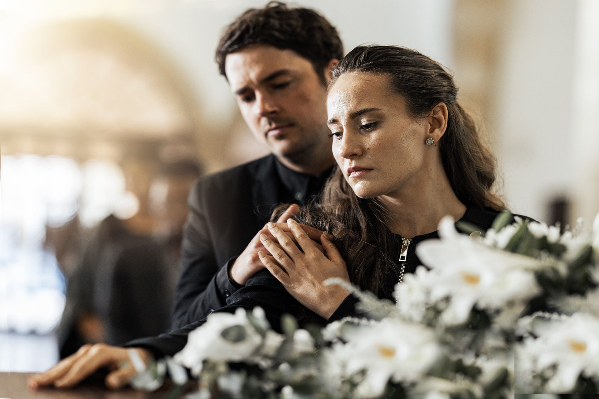 Couple at casket mourning loss of loved one