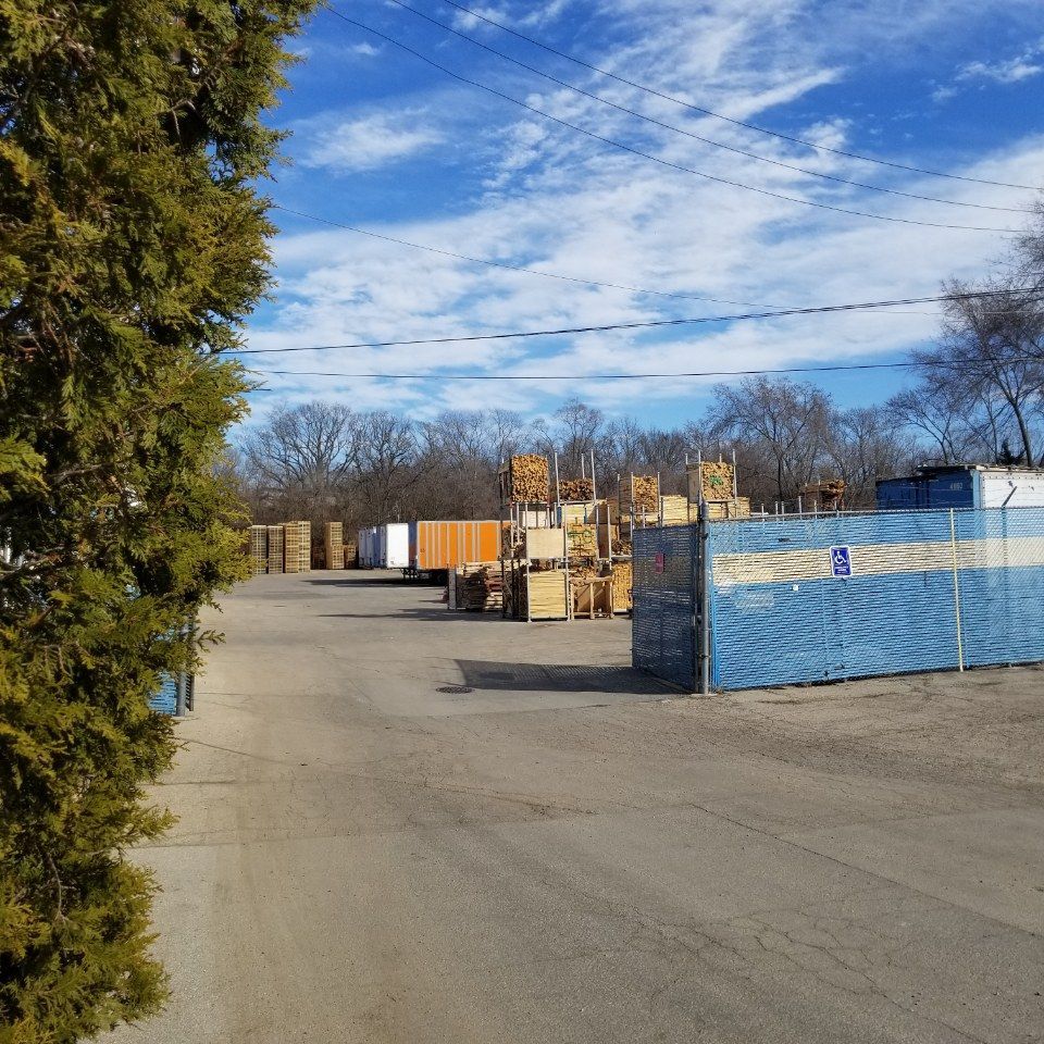 A row of containers are lined up in a parking lot