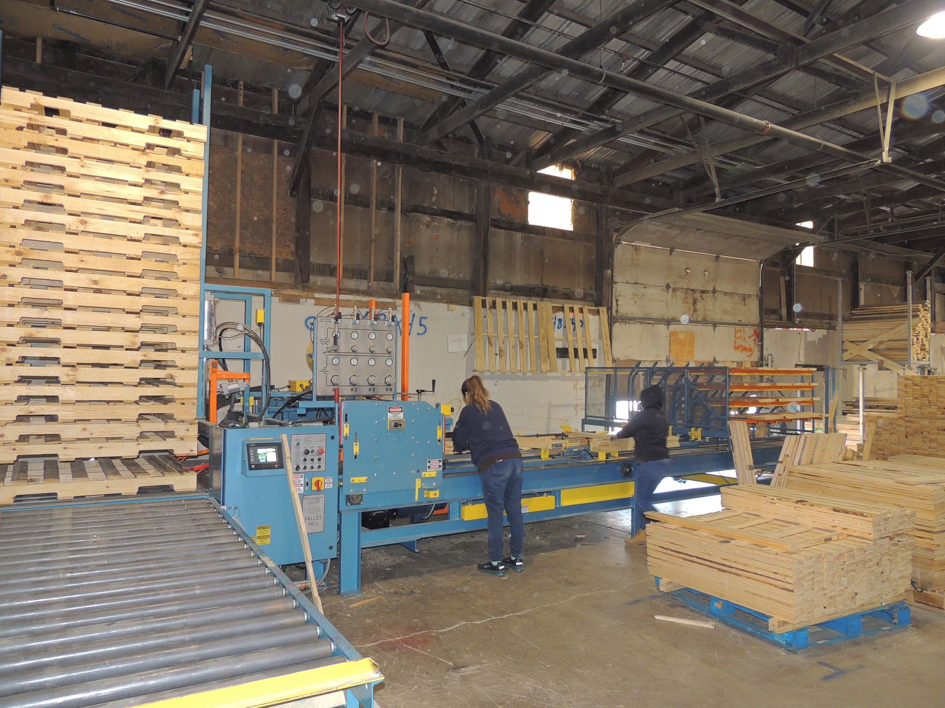 A woman is working on a machine in a warehouse