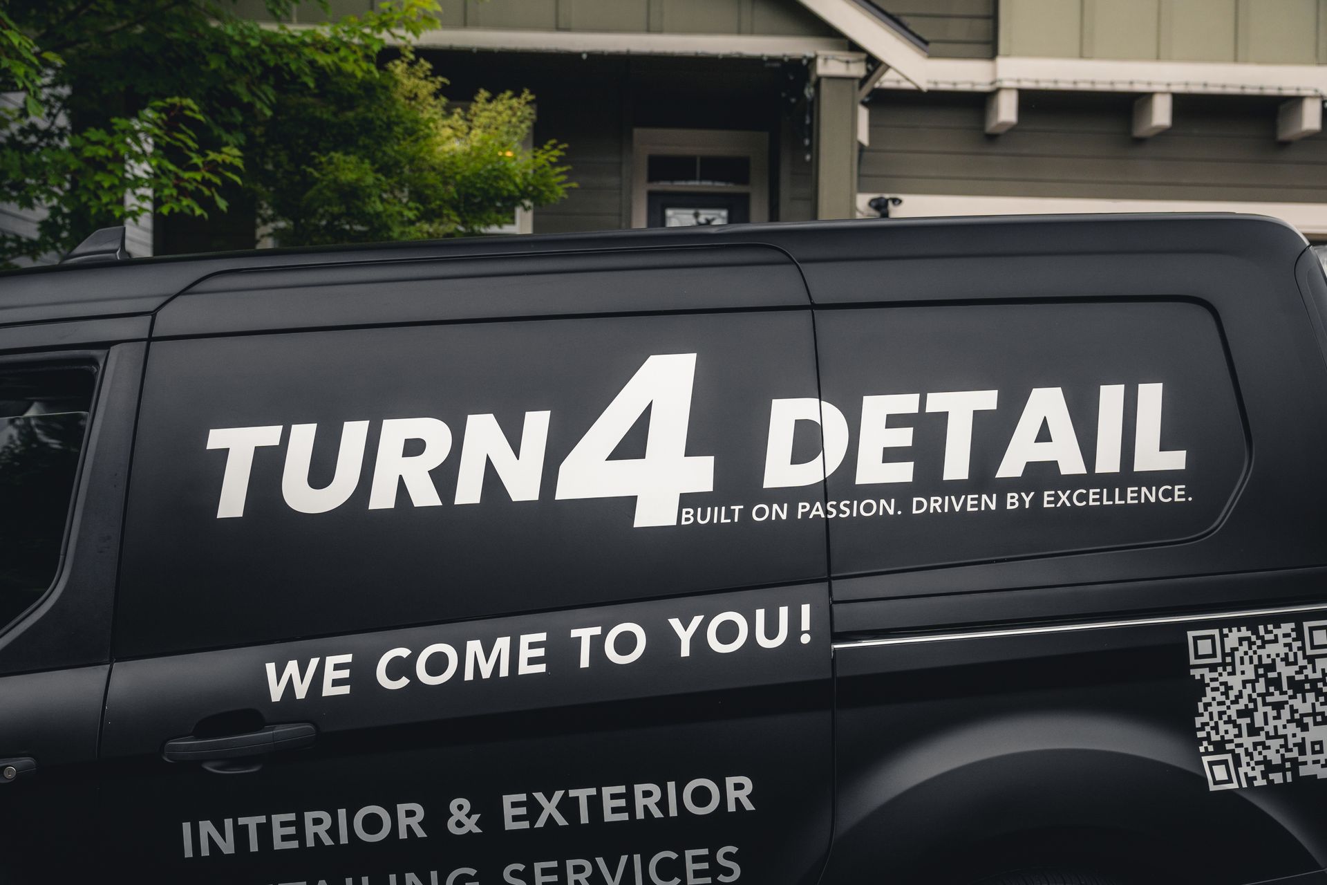 Black van with “TURN4 DETAIL” branding and service text parked in a driveway.