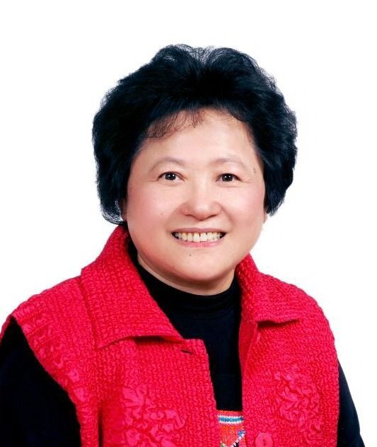 Portrait of a smiling person in a bright red jacket against a white background