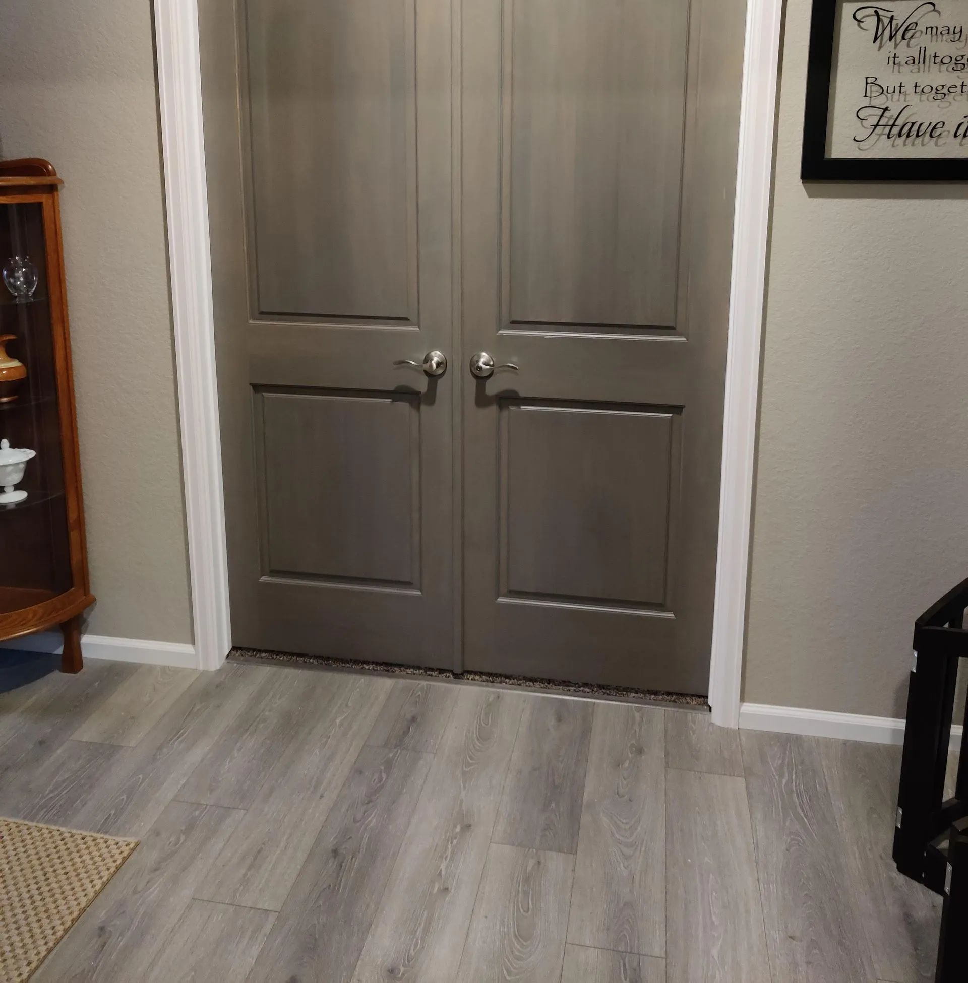 Gray double doors in a room with light wood flooring and white trim