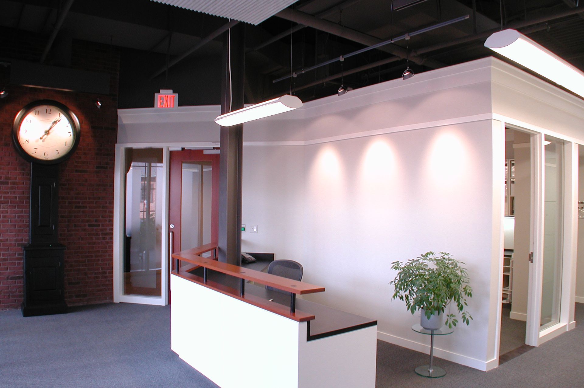 A reception area with a clock on the wall and an exit sign