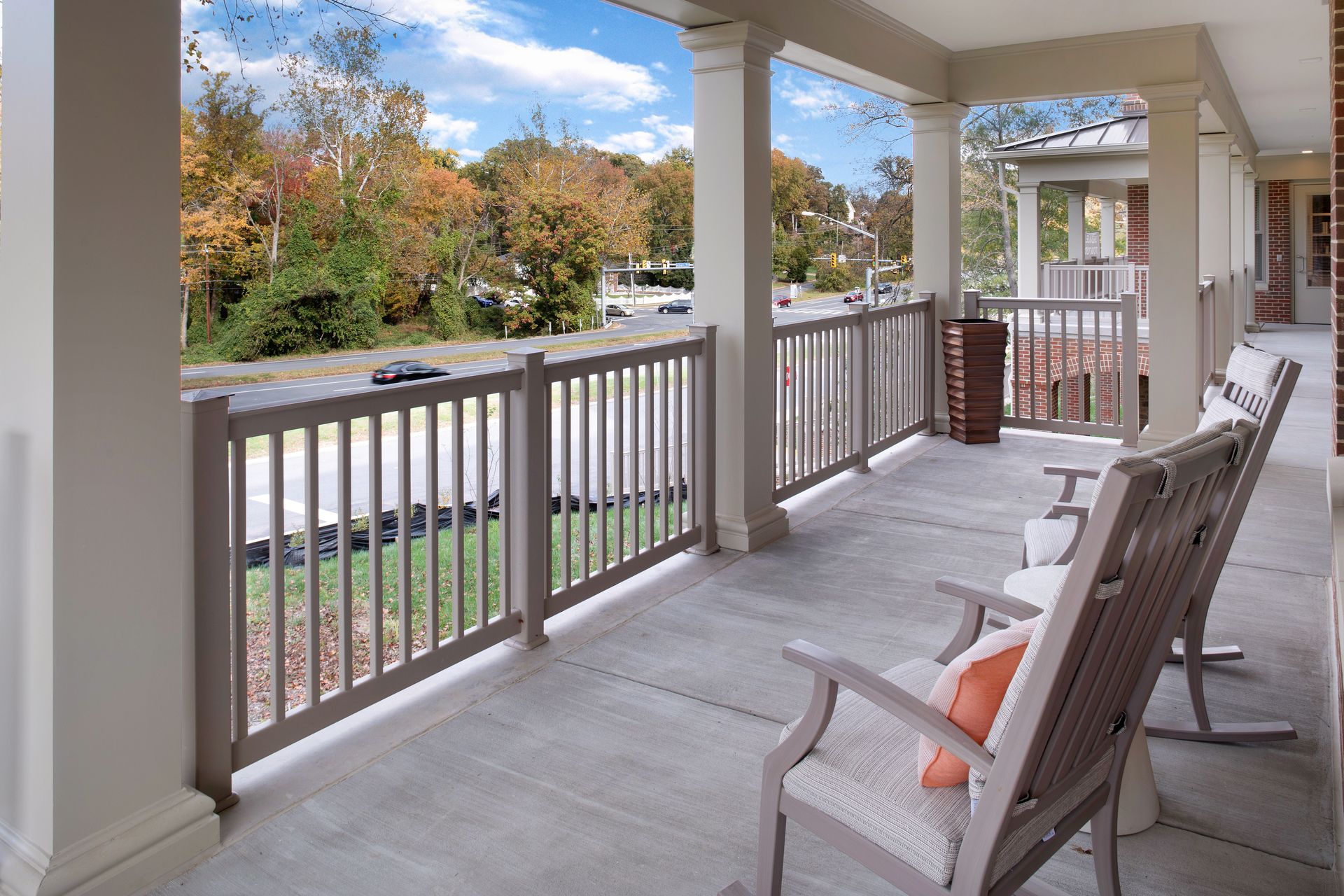 A porch with two rocking chairs and a railing