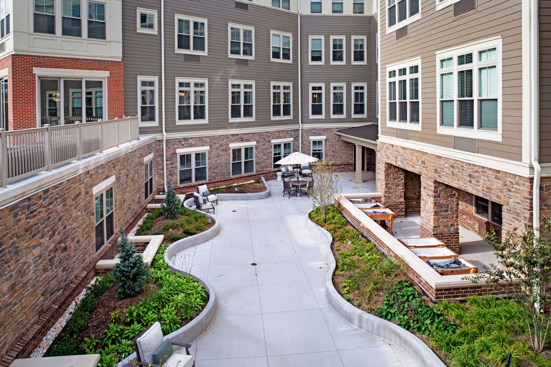 A large apartment building with a large courtyard in front of it.