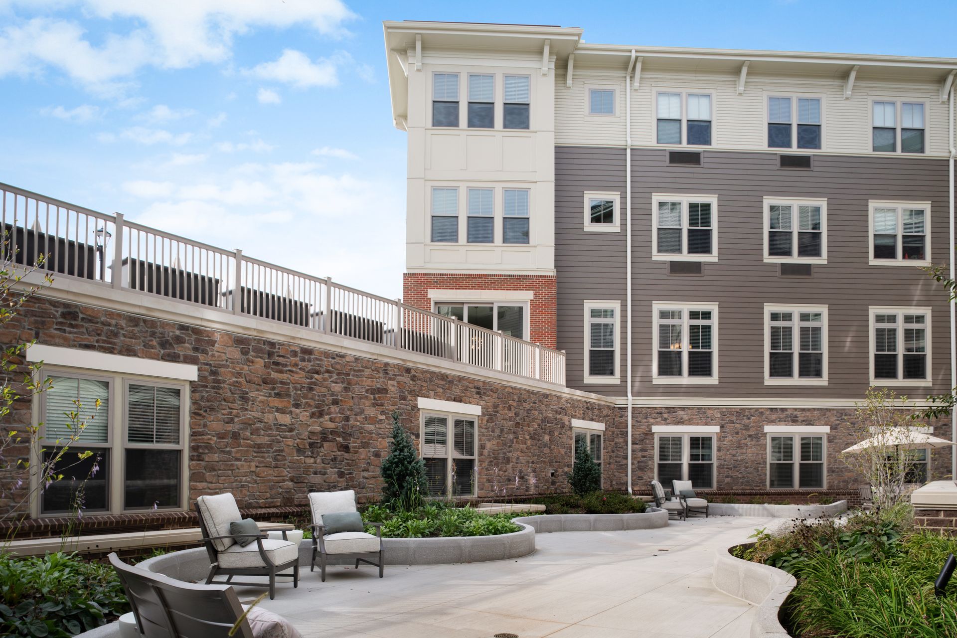 A large apartment building with a patio area in front of it.