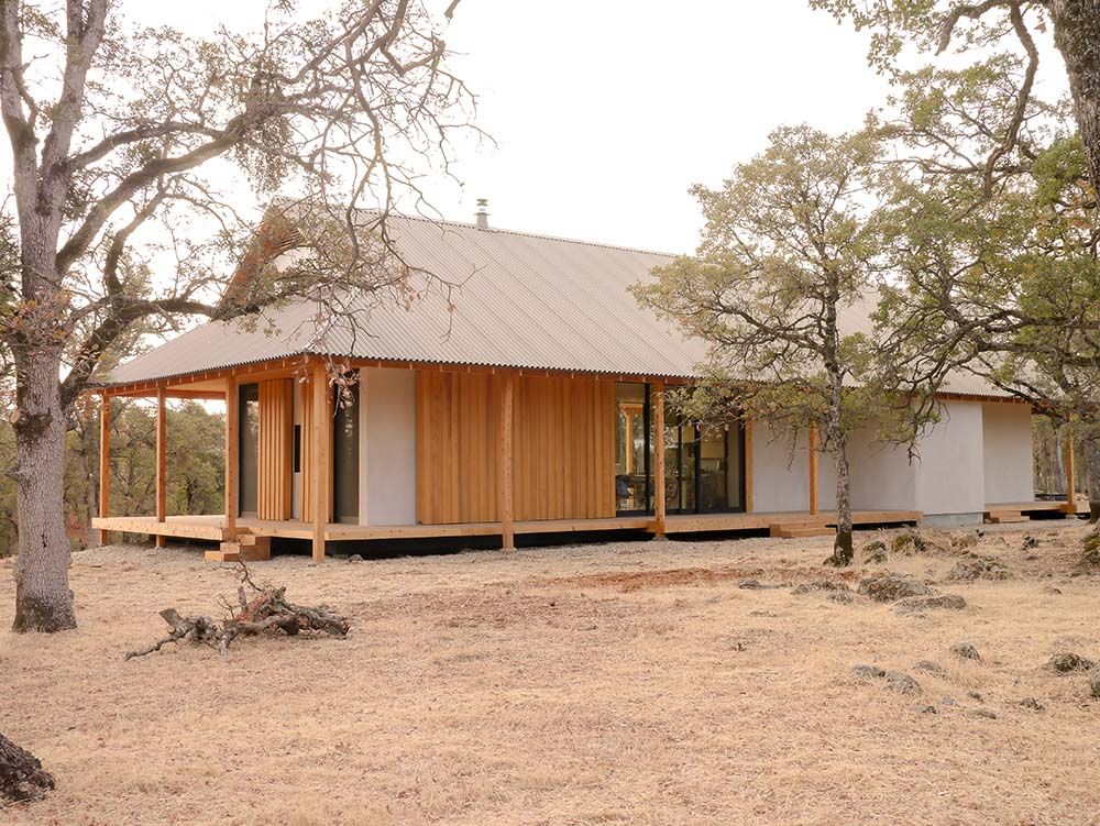A house with a porch and trees in the background