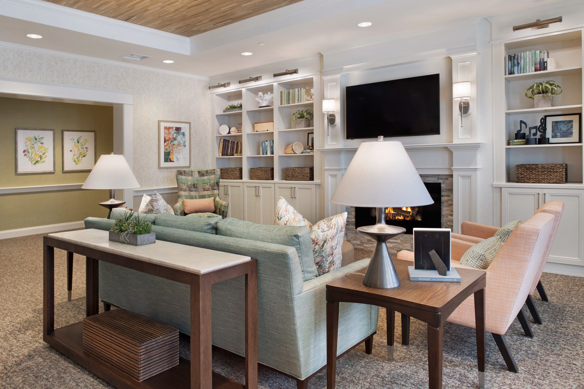 A living room with a couch , chairs , tables and a fireplace.
