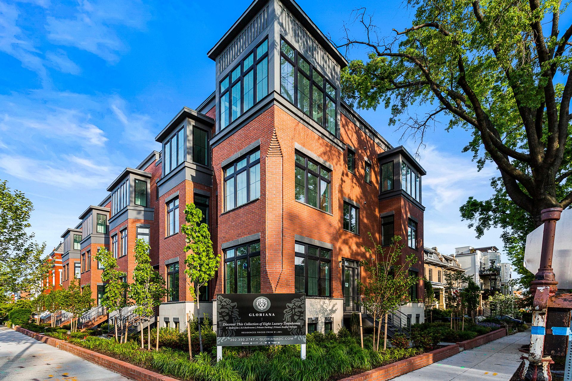 A large brick building with a lot of windows and trees in front of it.