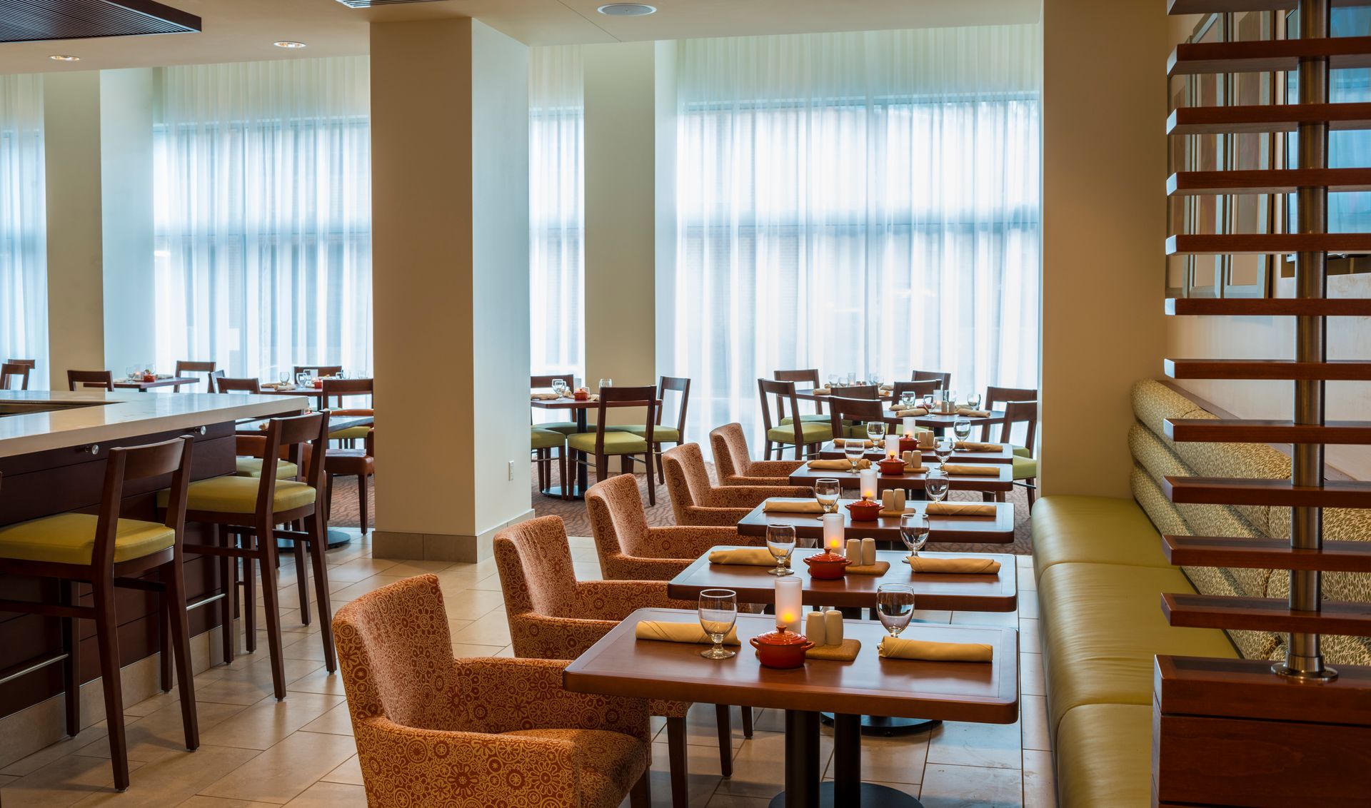 A restaurant with tables and chairs and a bar.