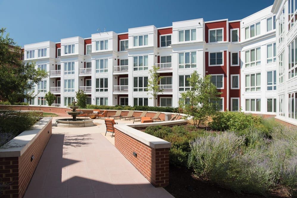 A large apartment building with a brick walkway leading to it