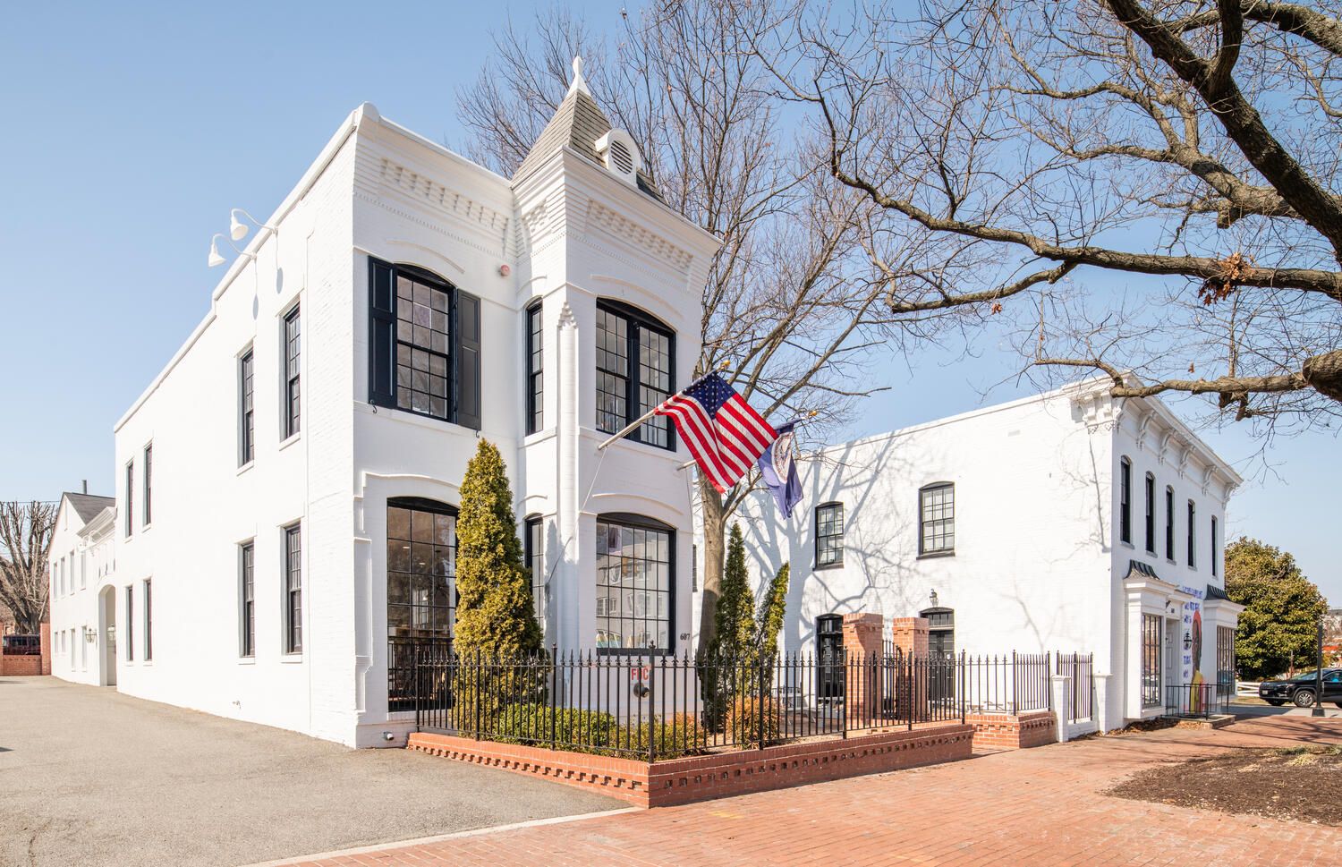 A large white building with an american flag flying in front of it.