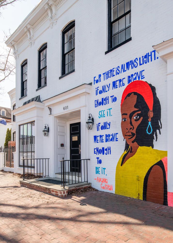 A mural of a woman is on the side of a building.