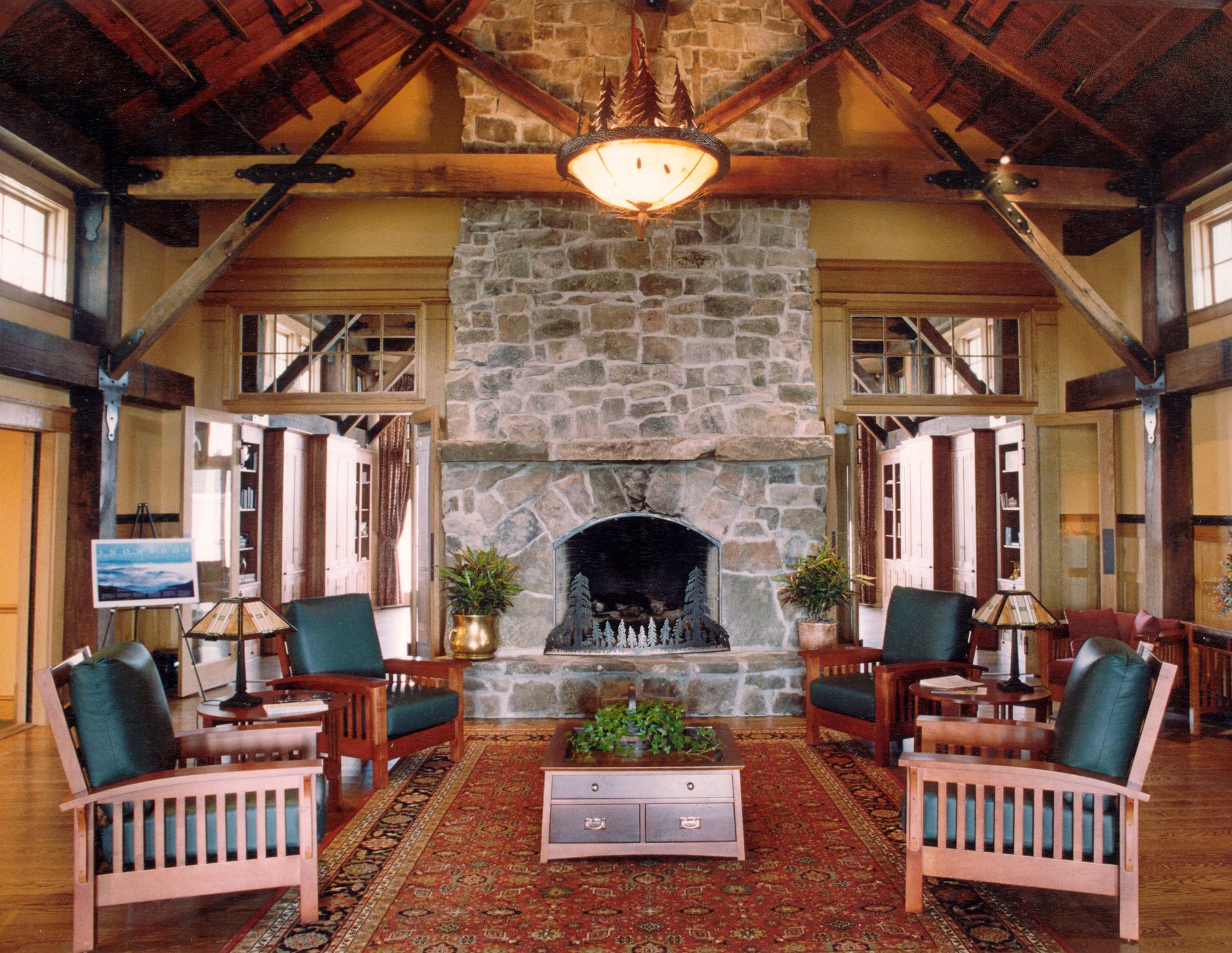 A living room with a stone fireplace and chairs