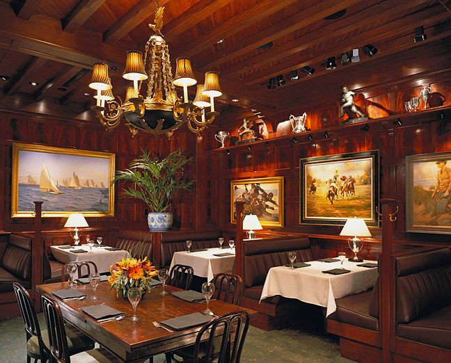 A dining room with tables and chairs and a chandelier