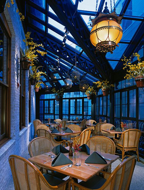A restaurant with tables and chairs and a glass ceiling