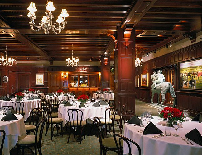A large room with tables and chairs and a statue of a man riding a horse