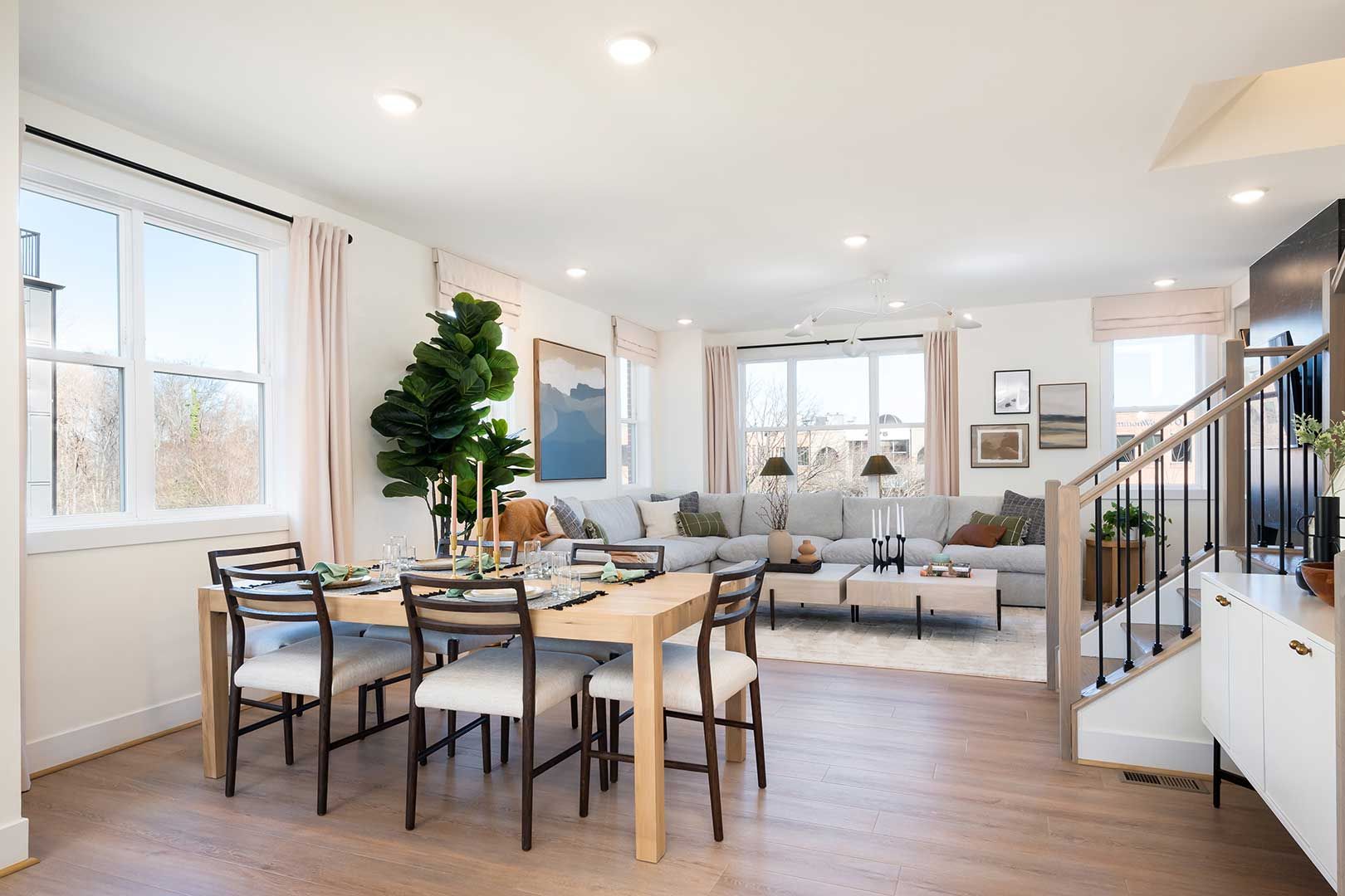 A living room with a dining table and chairs and a staircase.