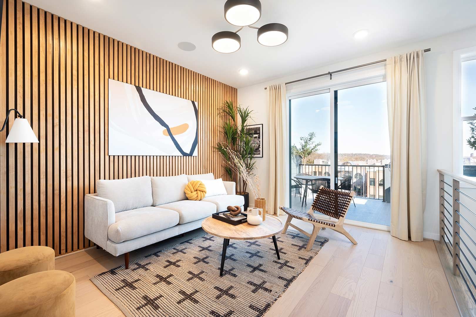 A living room with a couch , table , chairs and sliding glass doors.