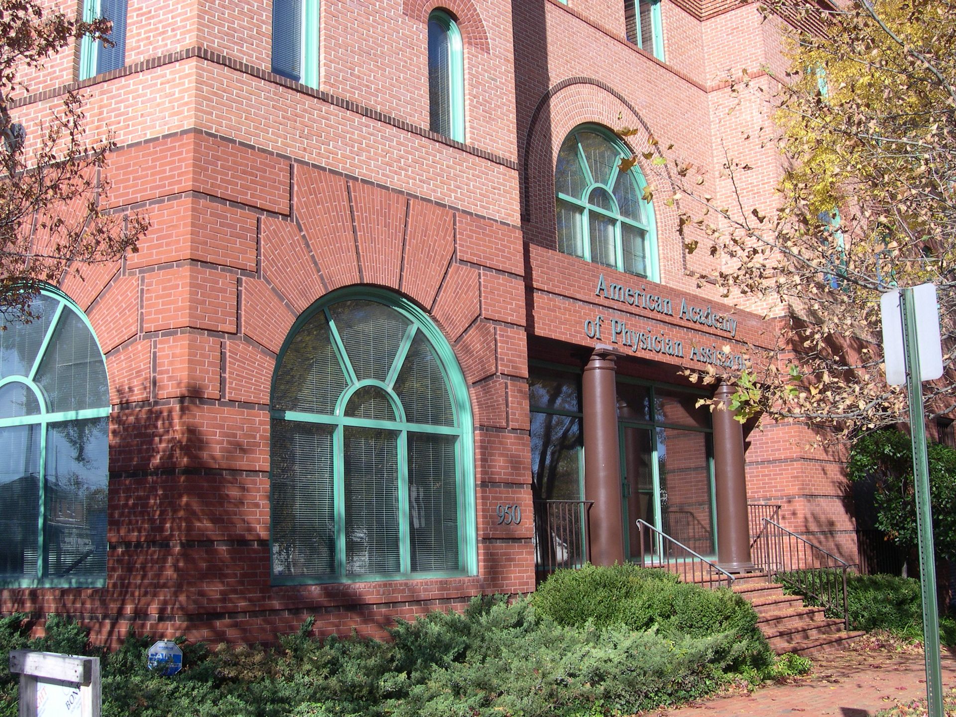 A large red brick building with green arched windows