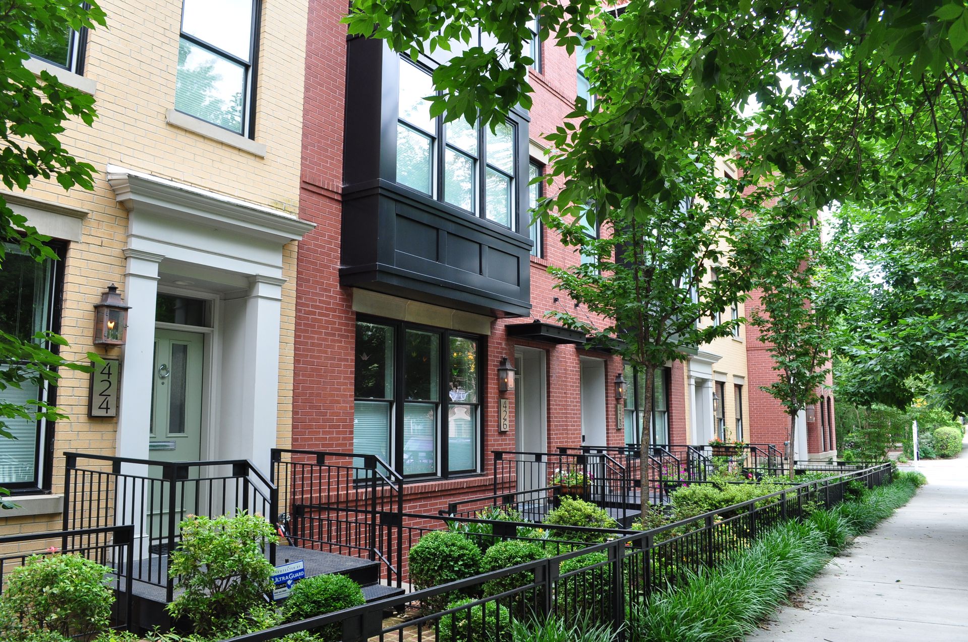 A row of brick houses with a black fence in front of them