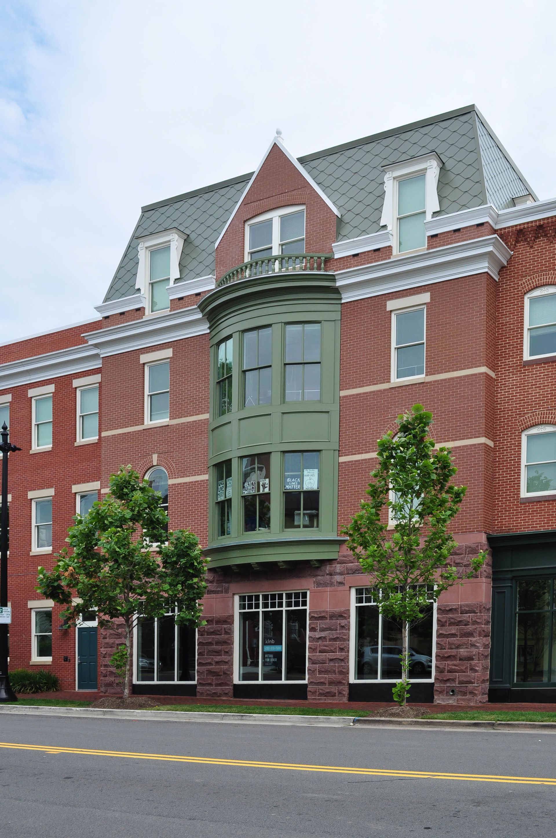 A large red brick building with a green balcony
