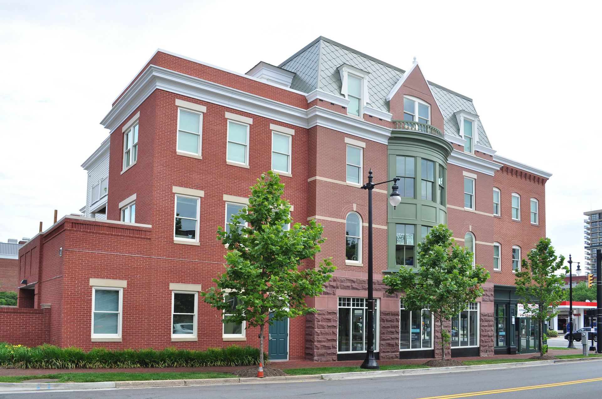 A large brick building with a lot of windows and trees in front of it