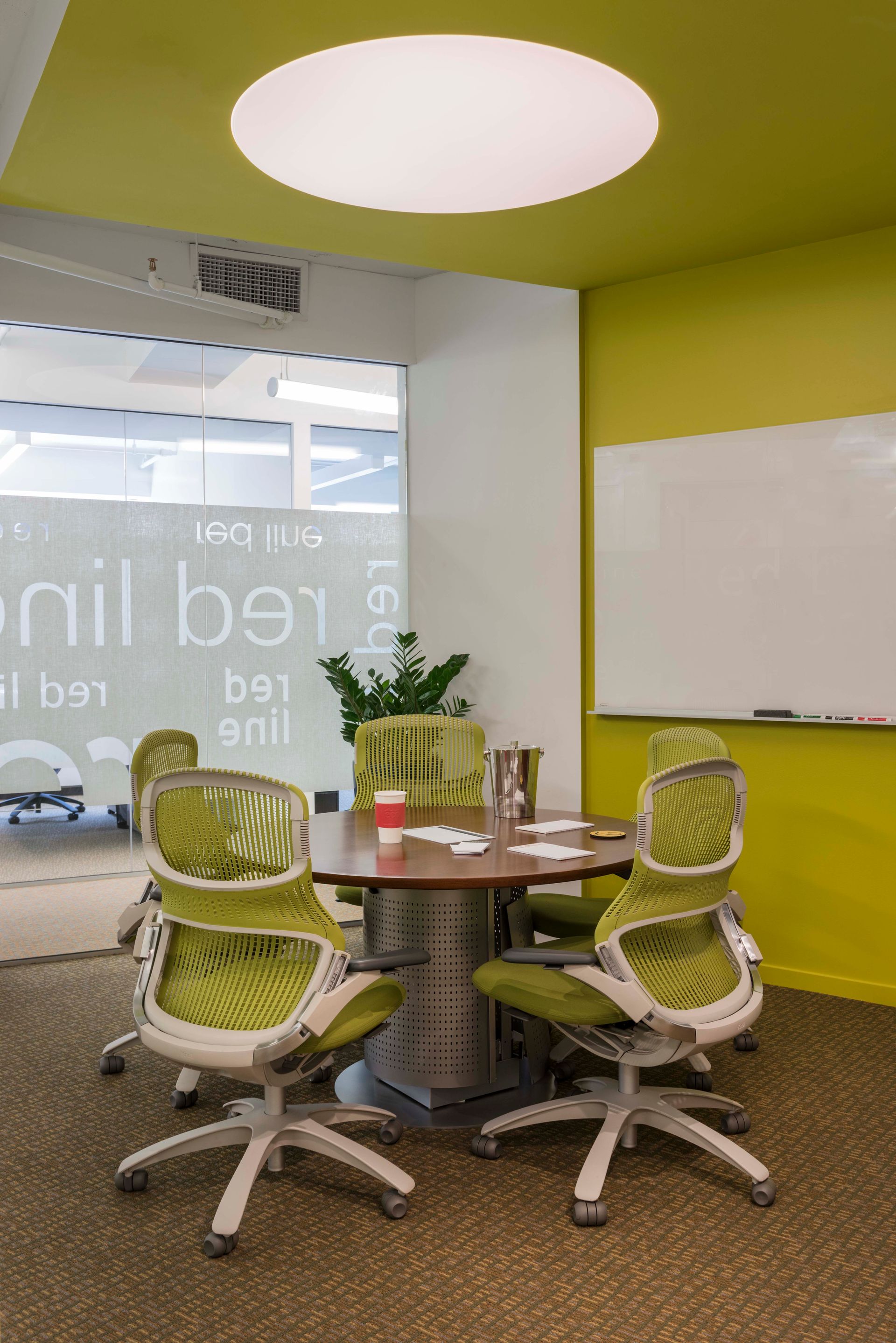 A conference room with a table and chairs and a whiteboard.
