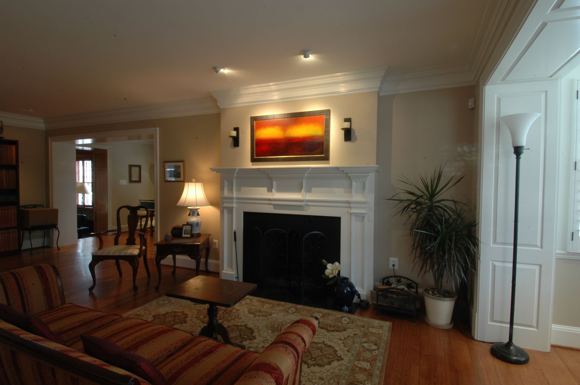 A living room with a fireplace and a painting on the wall