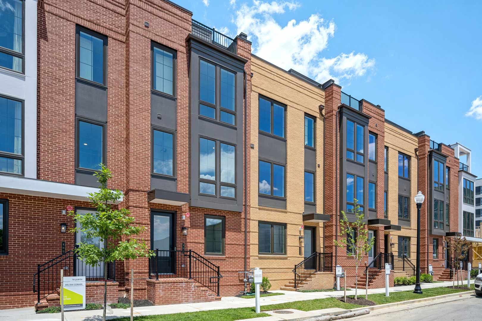 A row of brick buildings with lots of windows on a sunny day.