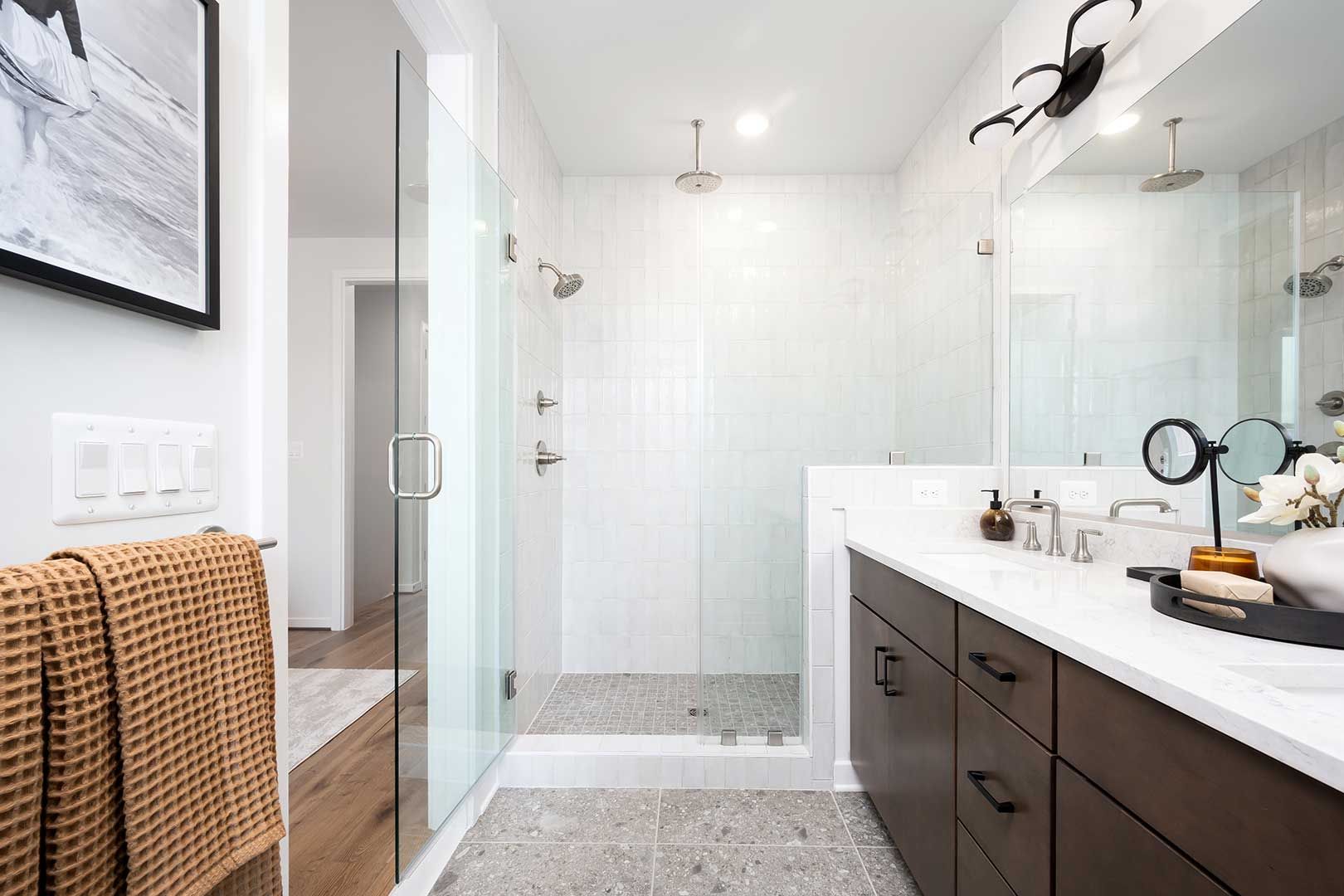 A bathroom with a walk in shower , sink and mirror.