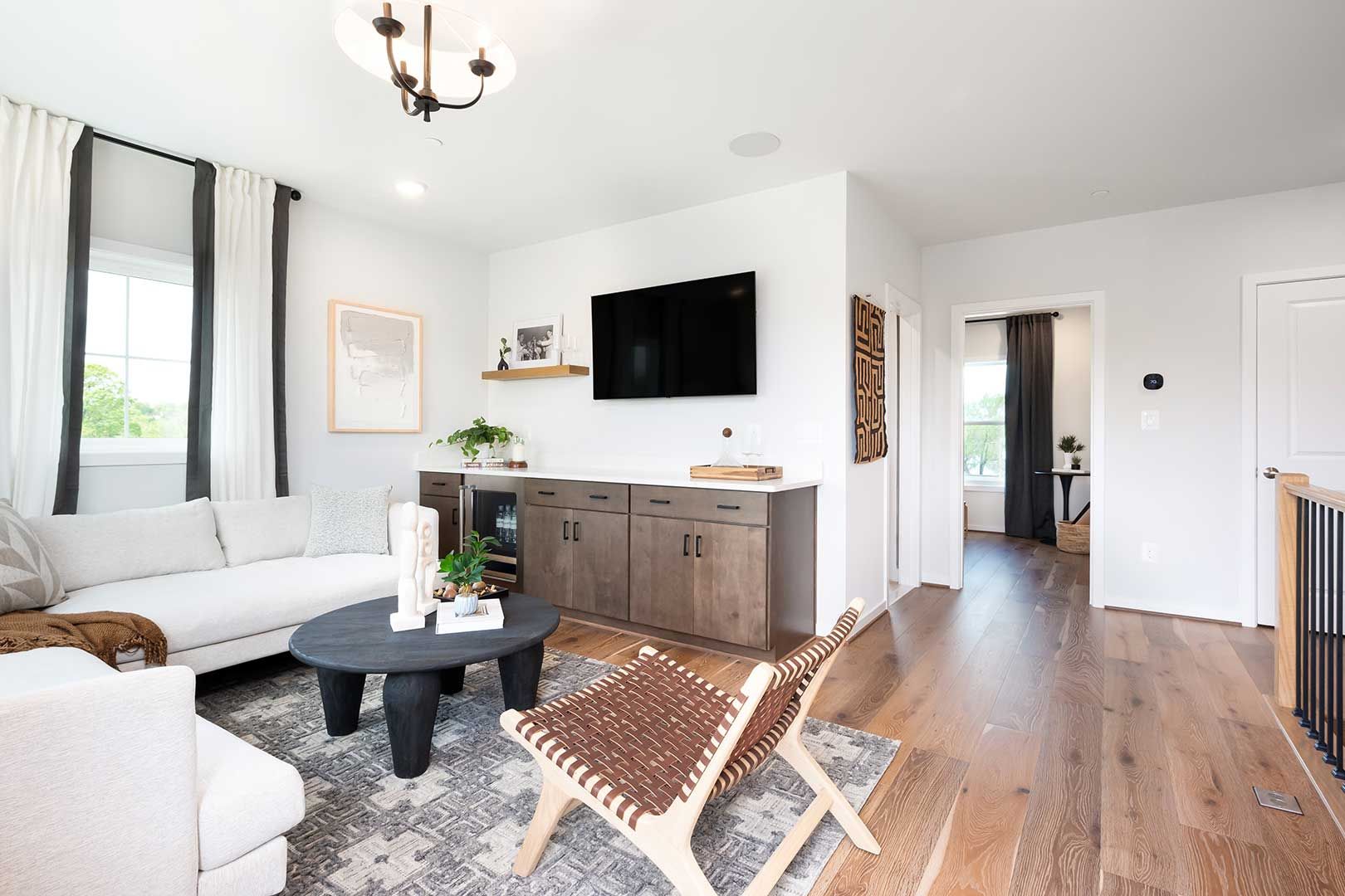A living room with a couch , table , chairs and a flat screen tv.
