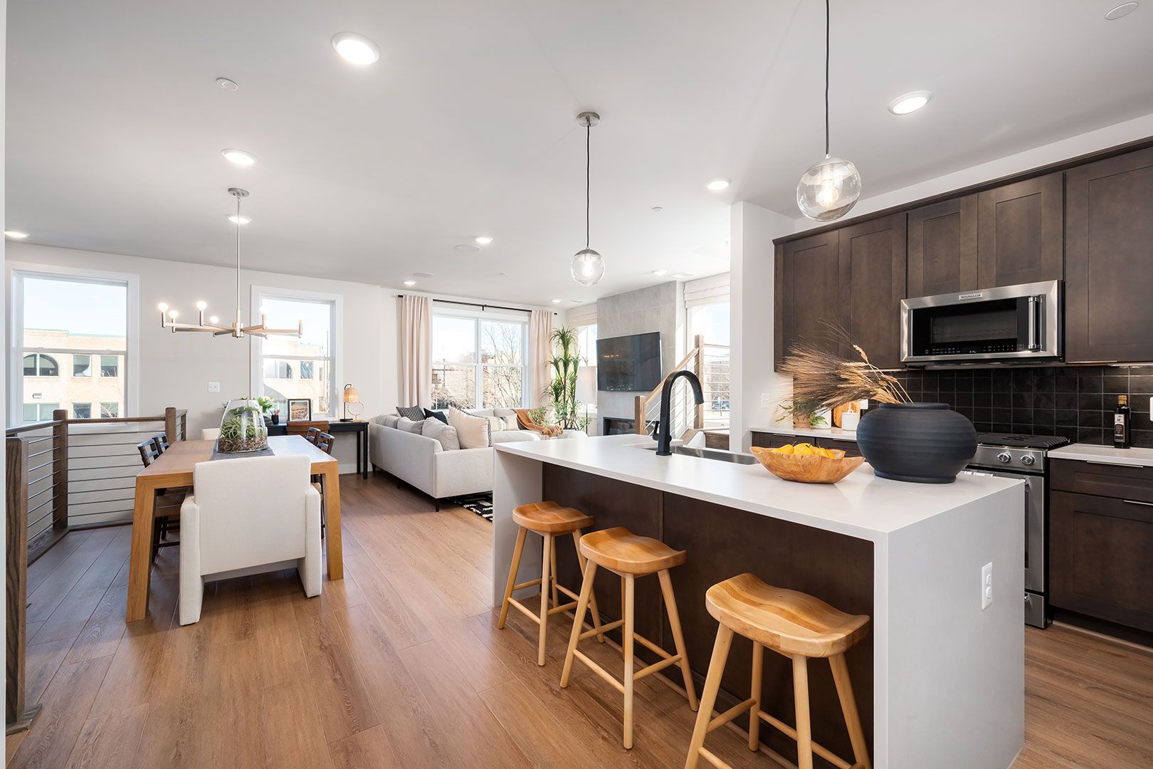 A kitchen with a large island and stools in a house.
