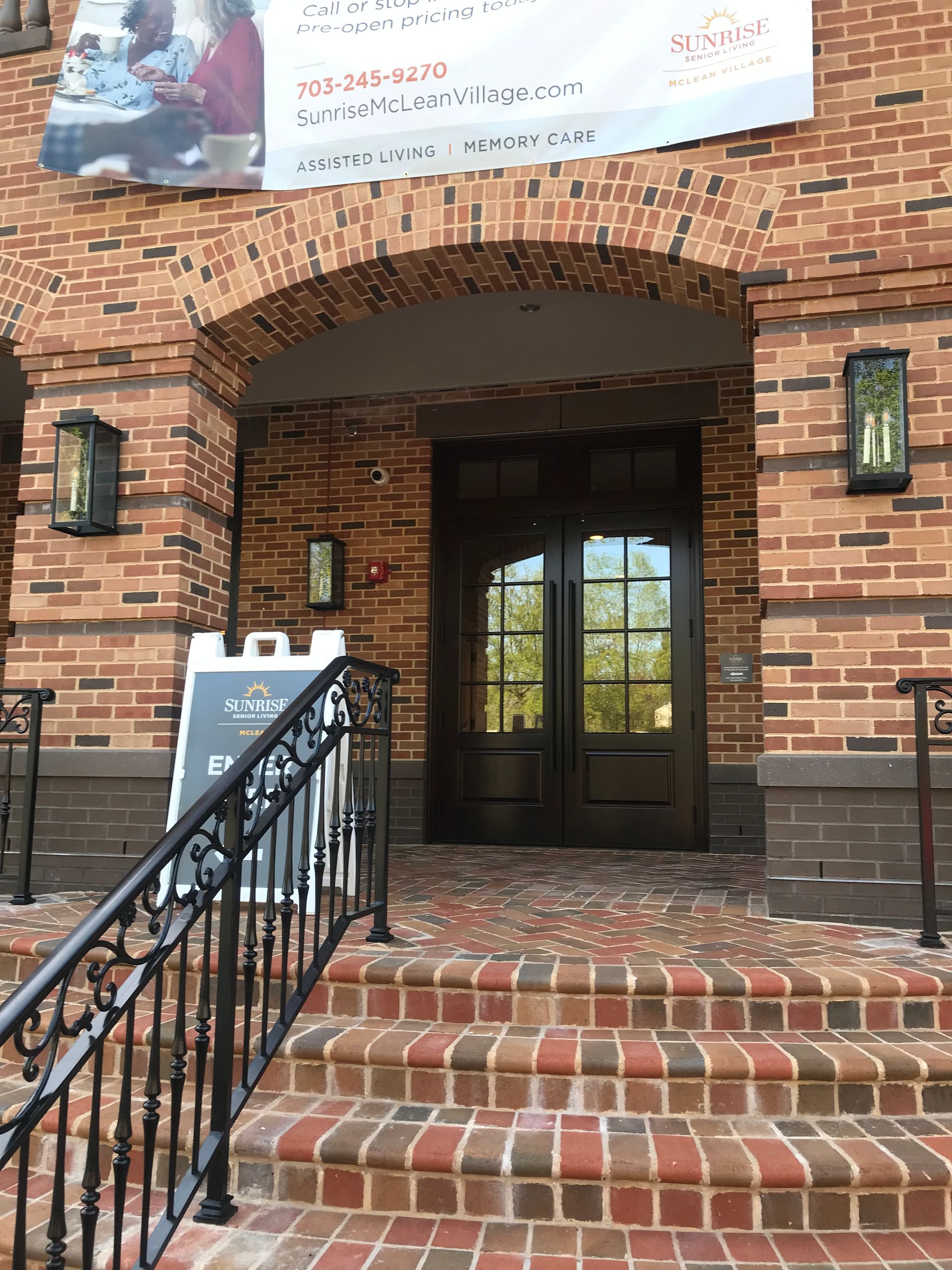 A brick building with stairs leading up to the entrance.