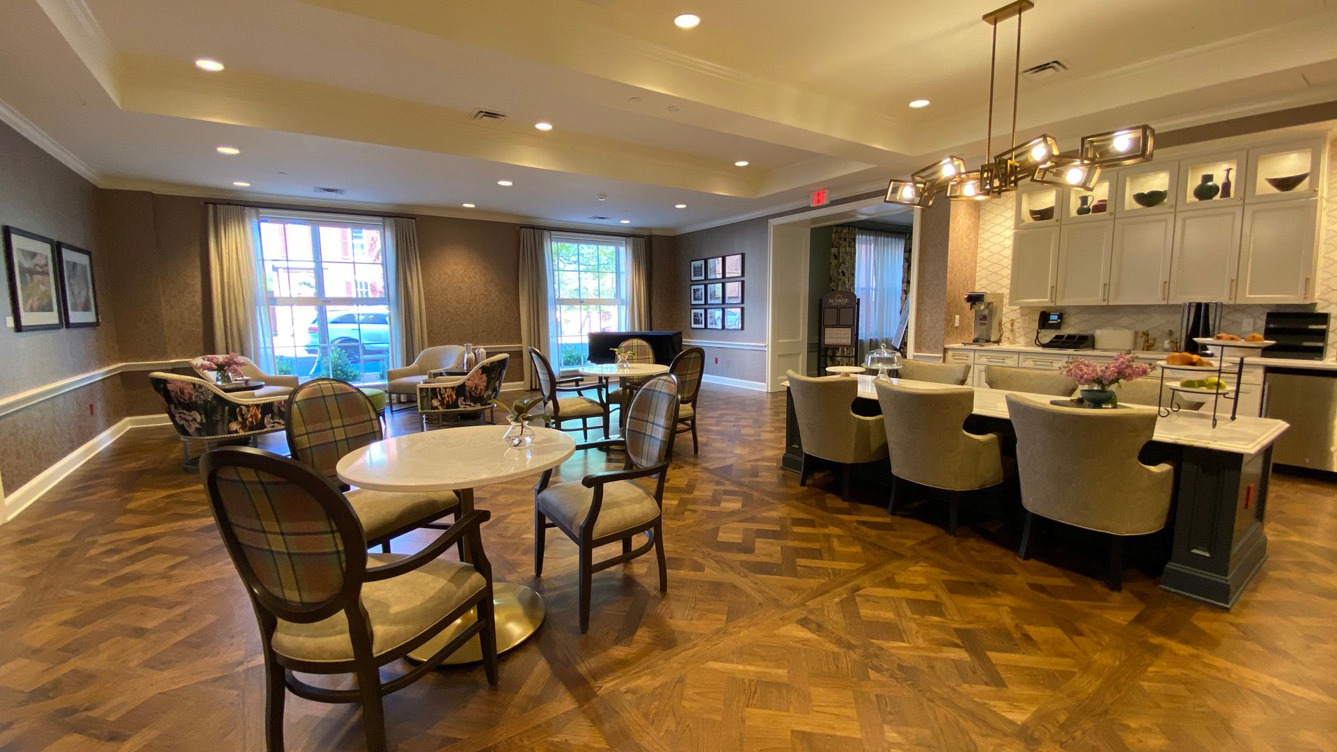 A large room with tables and chairs in it and a kitchen.