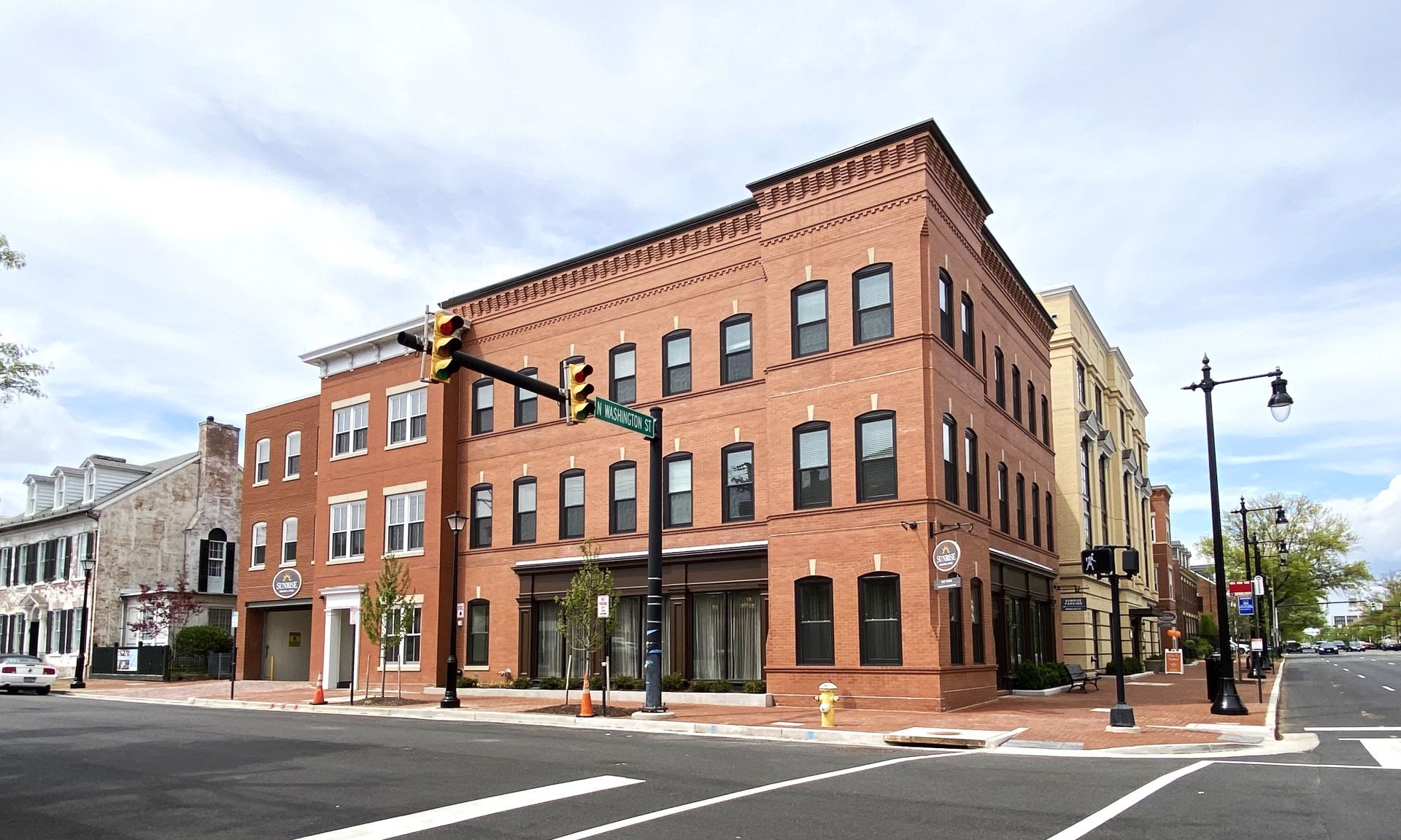 A large brick building is on the corner of a city street.