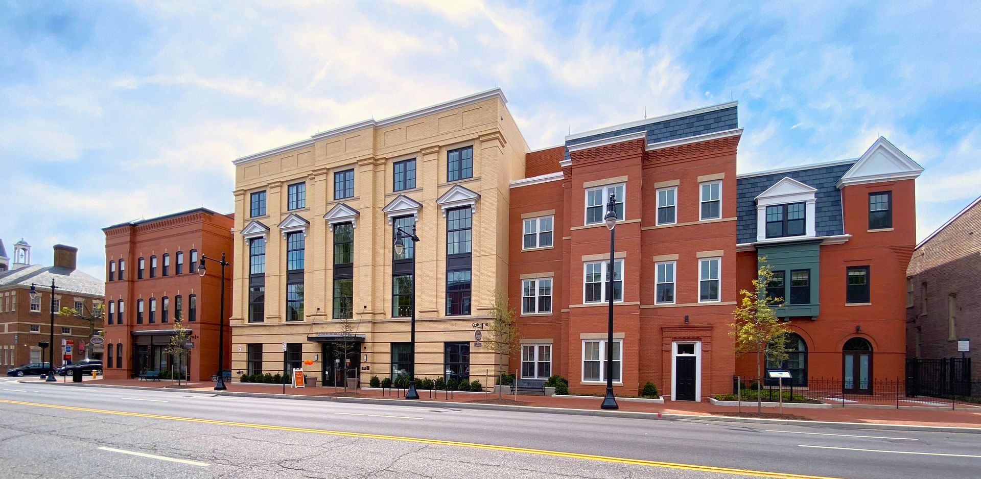 A row of brick buildings are lined up on the side of a street.