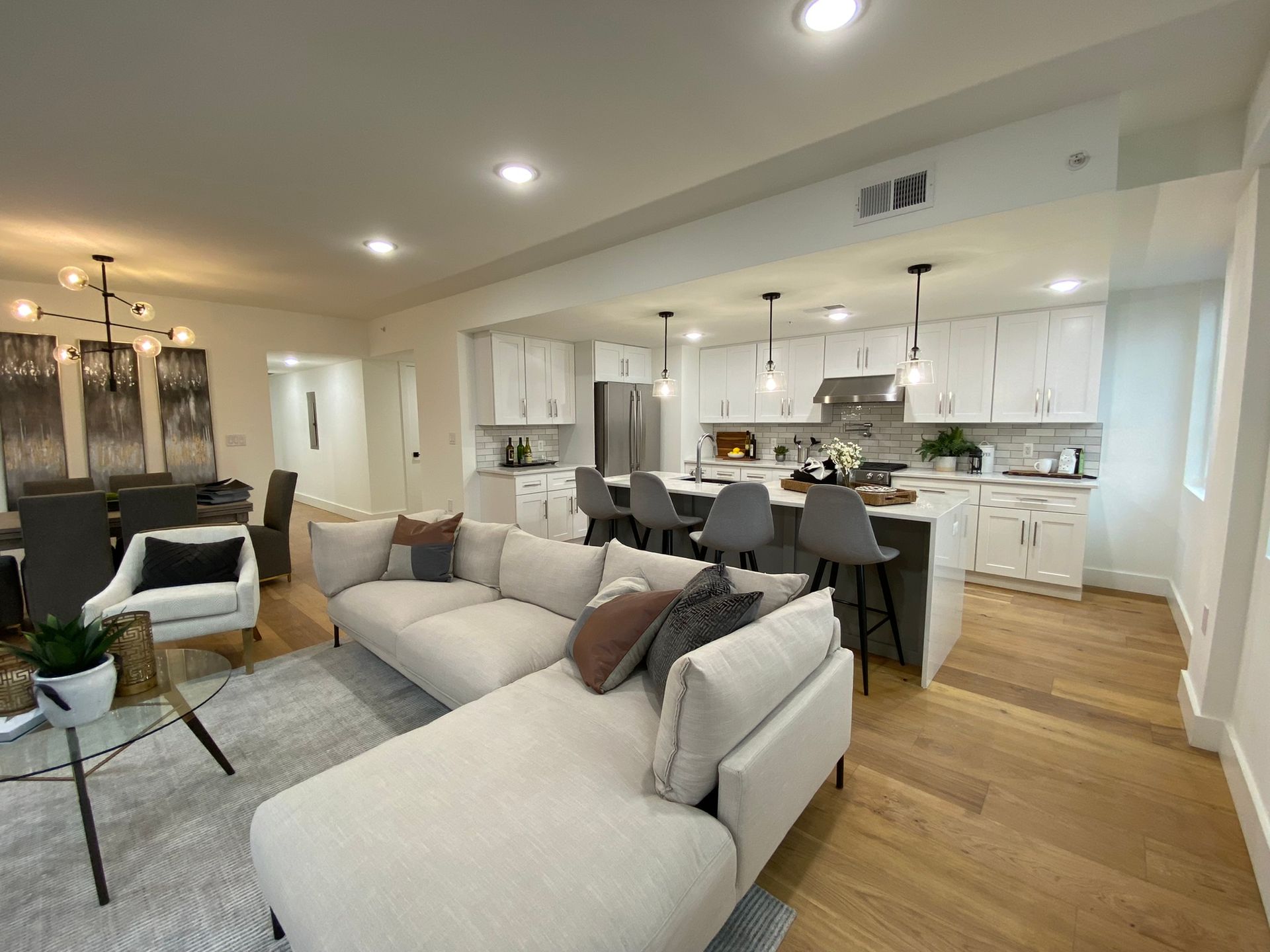 A living room with a couch and a kitchen in the background.
