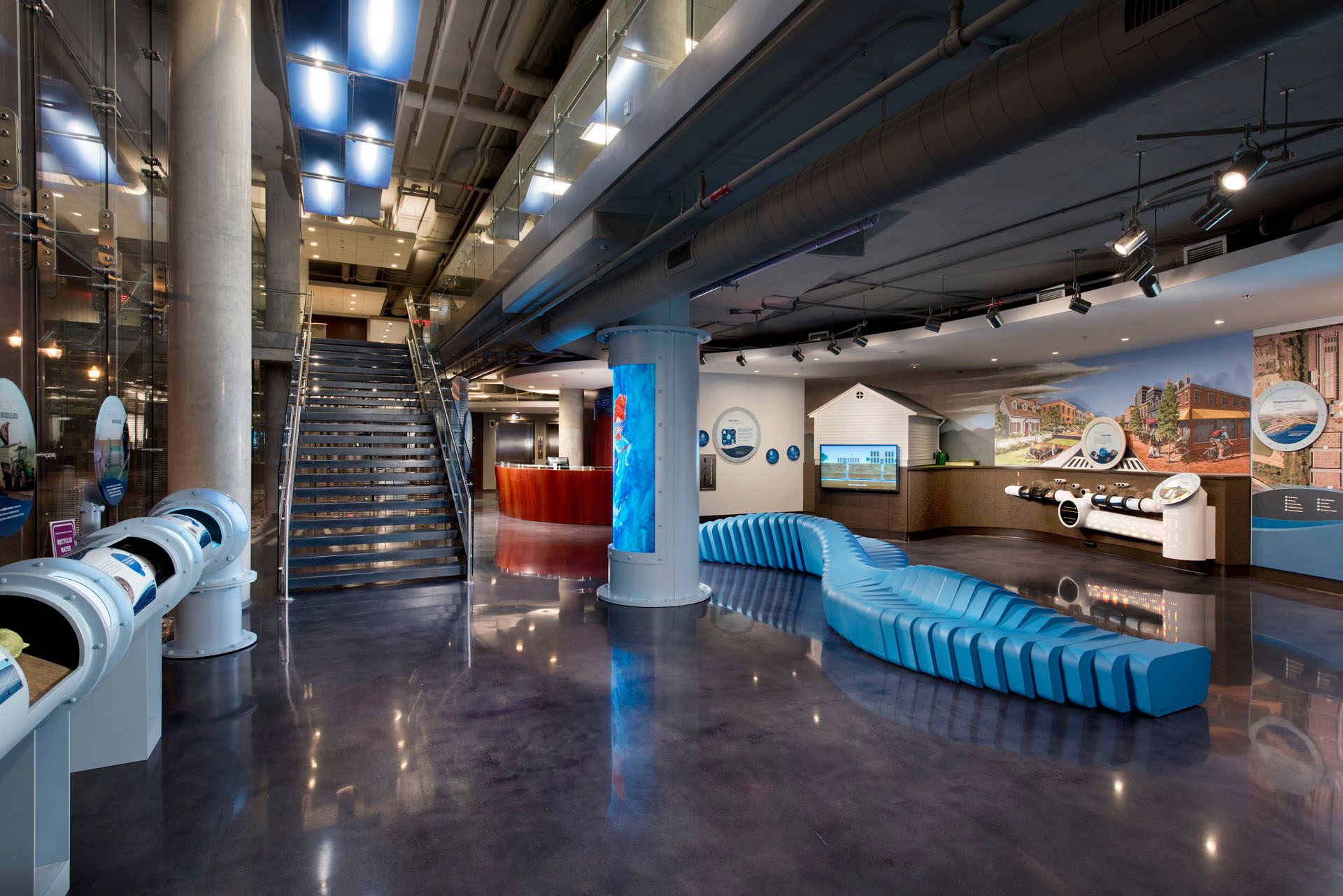 A large room with stairs and a blue bench